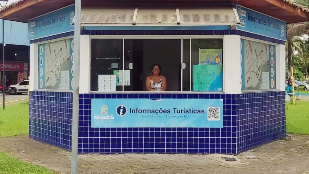 Atendente de turismo orientando visitante em centro de informações turísticas